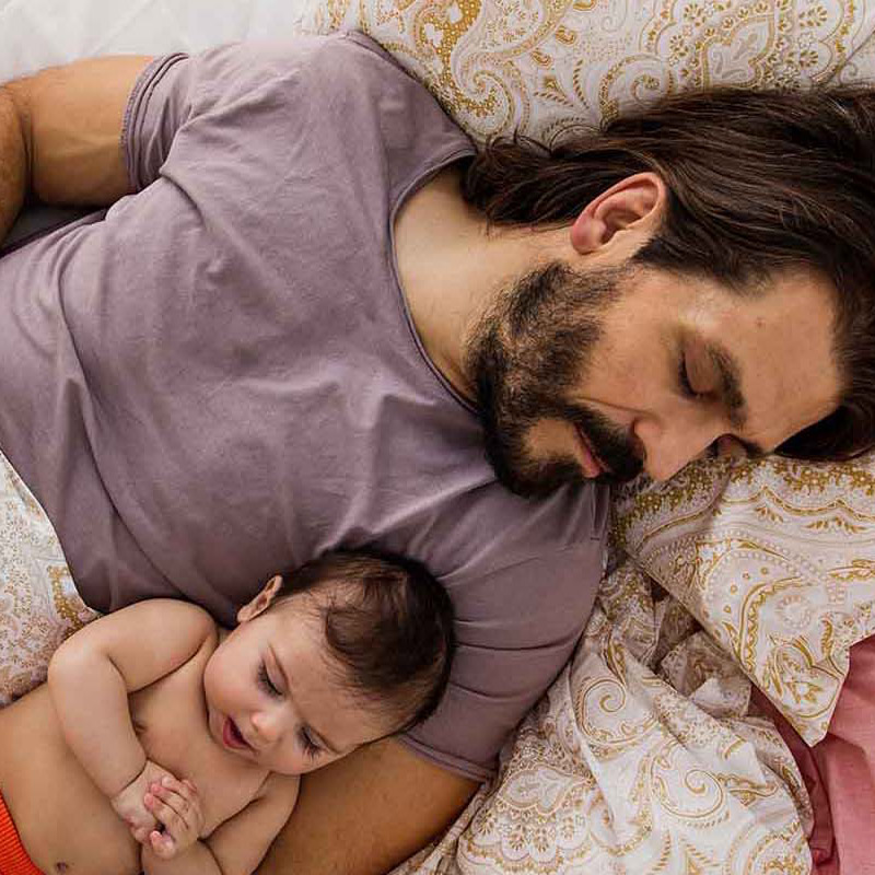 Vater mit Baby schläft bei angenehmer Raumtemperatur